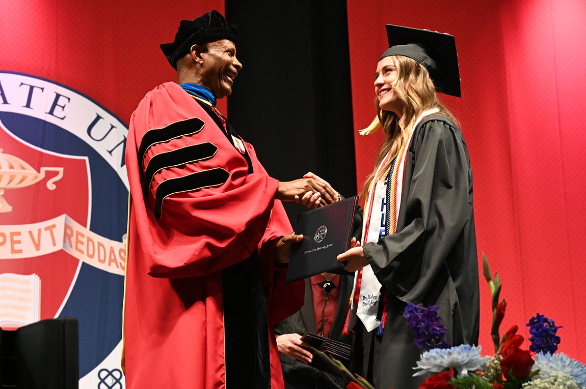 Shelby Robinette receiving diploma from Dean Rolston St. Hilaire