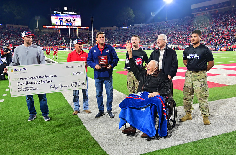 Rodger Jensen waves to crowd at Fresno State Football game and American Pistachio Growers presents $5,000 check to the Aaron Judge All Rise Foundation