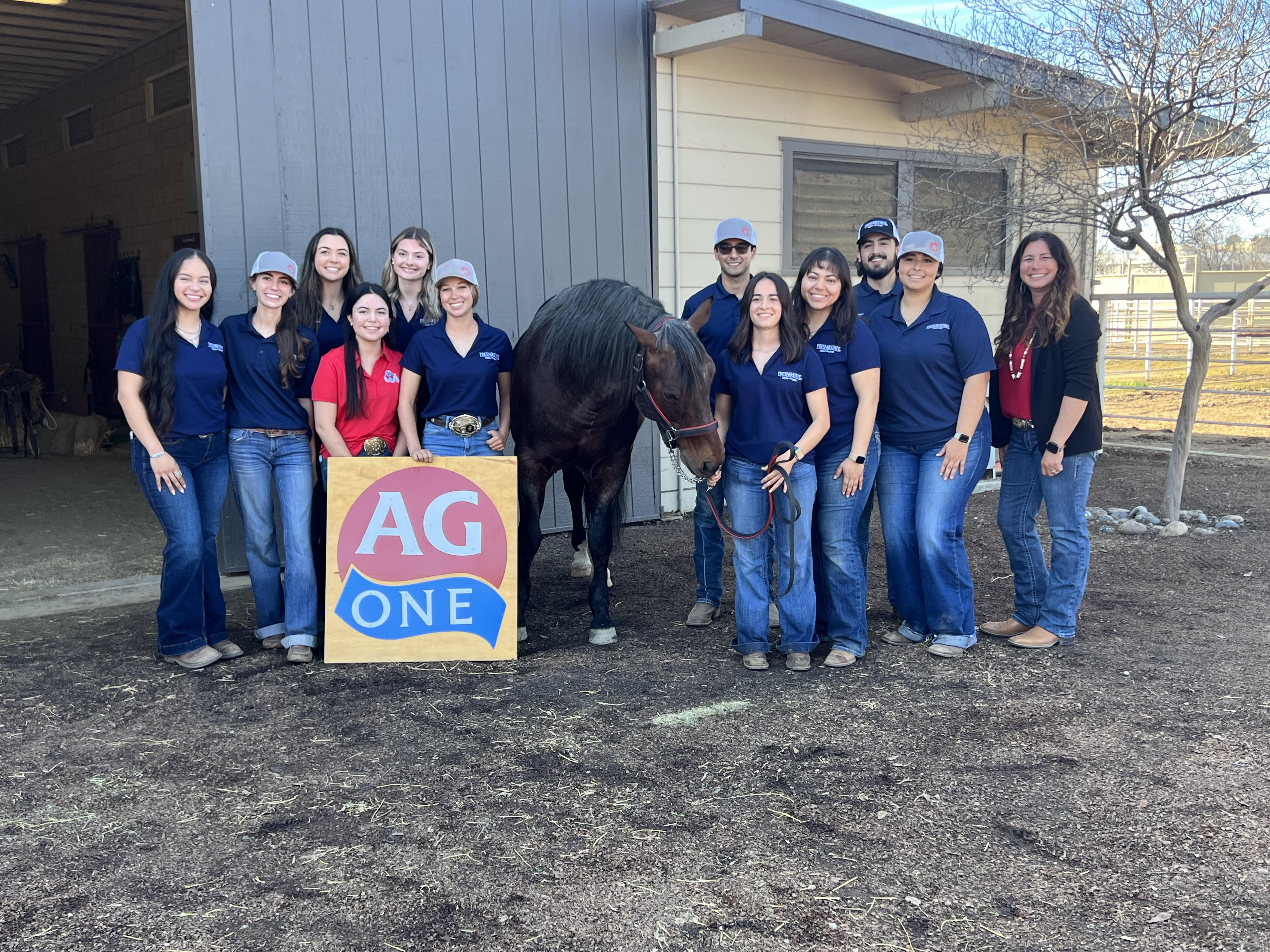 QHU employees and Interns posing with Fresno States stallion during Harris Farms Event