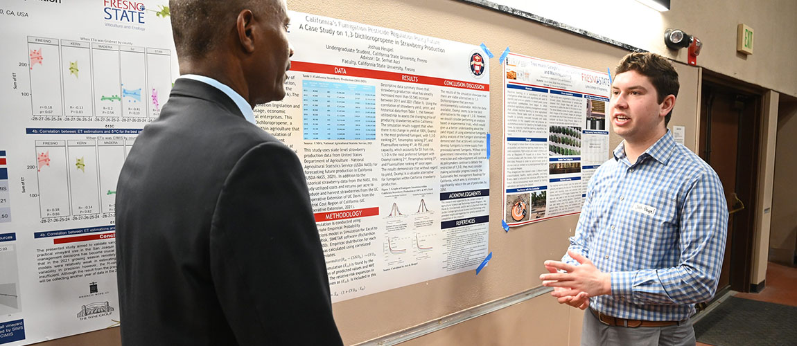 Josh Heupel explains his research to Jordan College Dean Rolston St. Hilaire