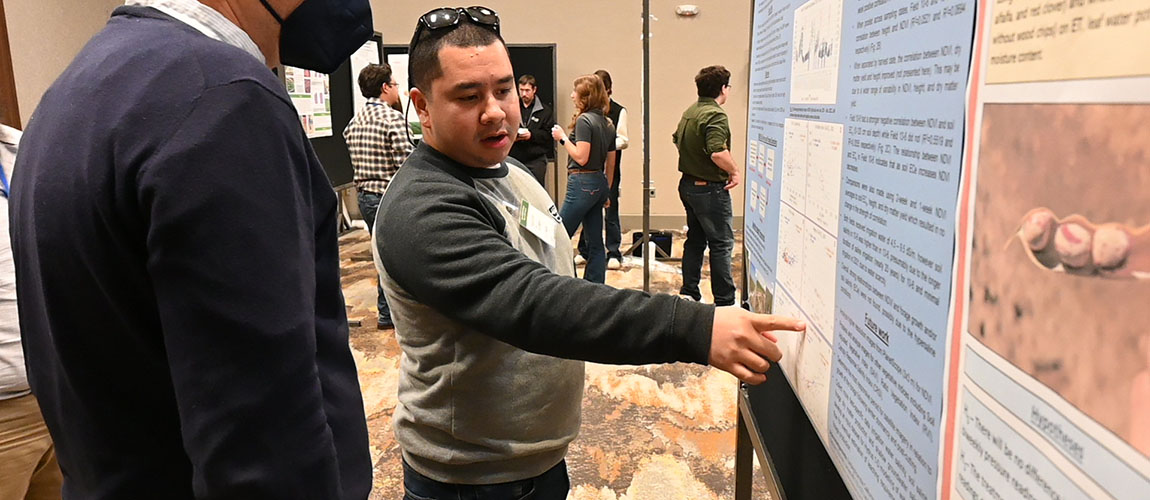 Mauricio Soriano discusses his plant science research at a conference.