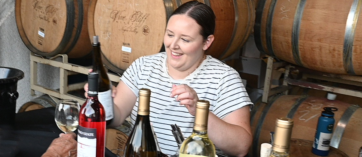 Shannon Dibble pours wine at a campus winery tasting.
