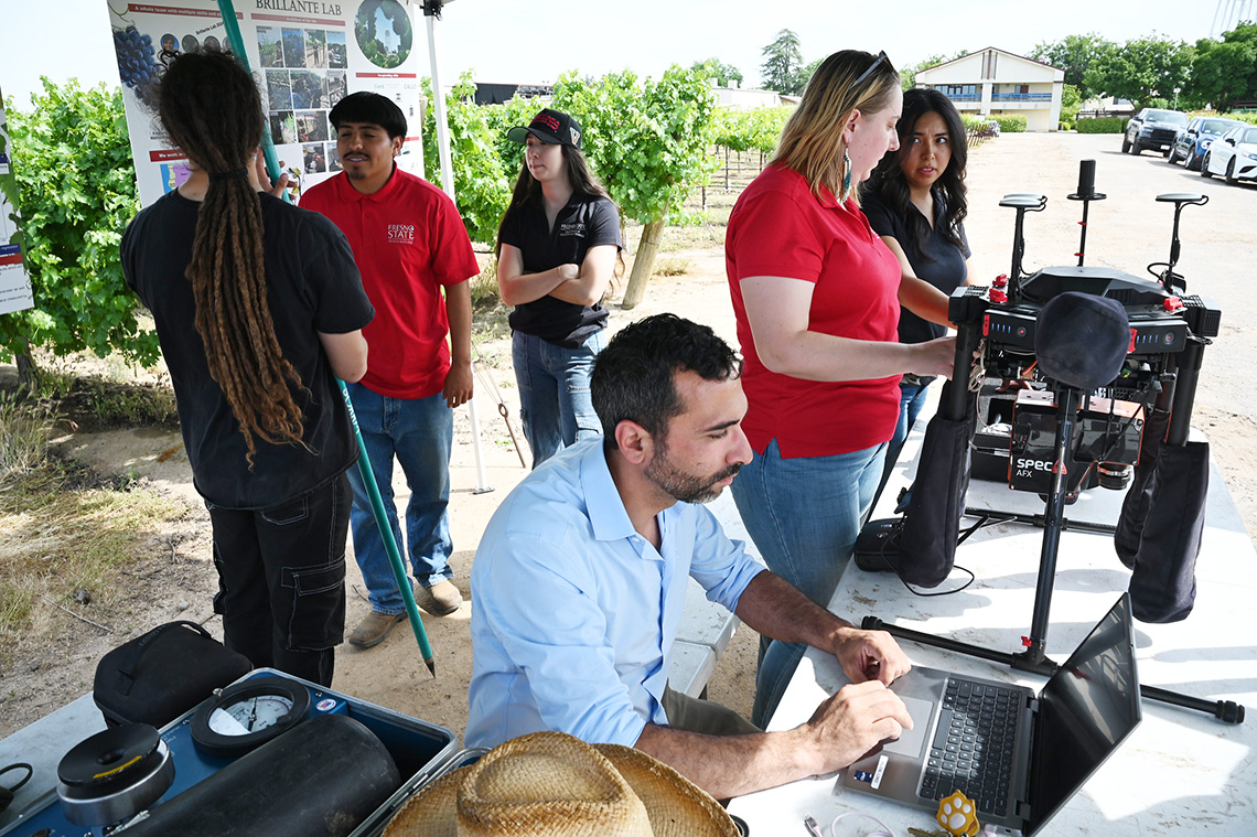Fresno State viticulture and enology faculty Dr. Luca Brillante, researchers Eve Laroche-Pinel and Diego Freire, and students Melissa Carbajal, Lupita Partida, Xavier Rideout and Adan Solis showcase research equipment for their project analyzing vine health through remote sensing and drone technology.